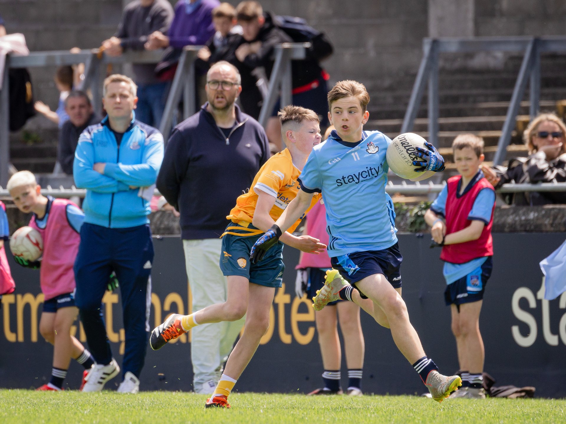 Hunter Maher, St. Malachy’s, Edenmore, on the attack with coaches, Pádraig Ó Conchubhair( Áth Cliath) and Diarmaid Eagney (Mayo) looking on.  Image