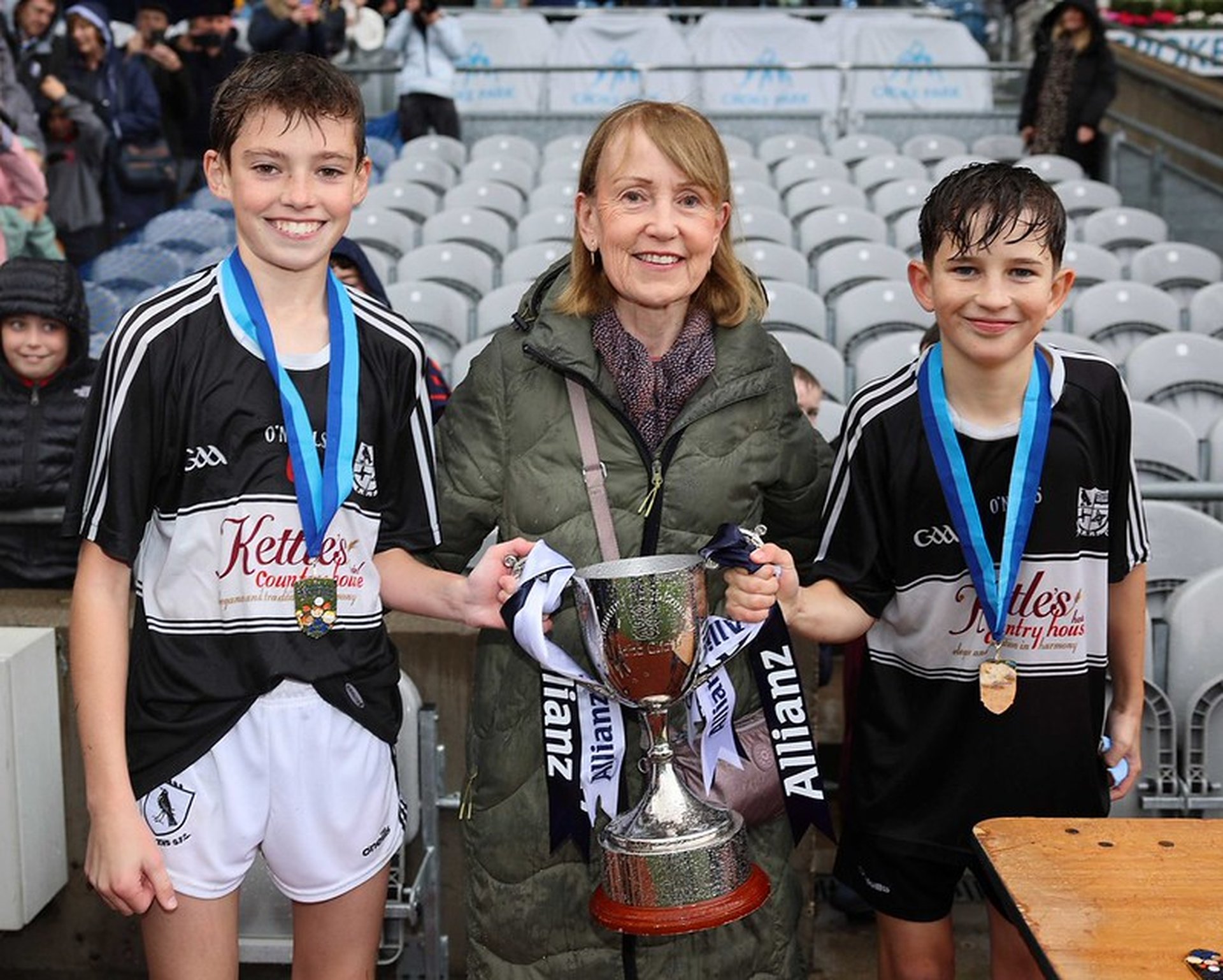 Maeve Nagle presents Corn John Nagle to Rolestown joint captains Tommy Brennan and David Oʻ Connell Image
